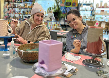 Hannah Barrett and Katelyn Sainz painting pottery